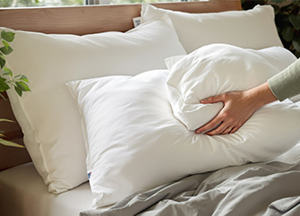 Daunenkissen aufschütteln für mehr Bauschkraft