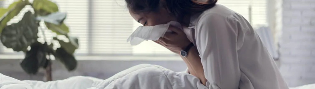 Allergikerin niest im Bett